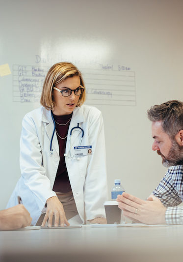 Medical staff having conference meeting in hospital Female leadership. Medical staff having conference meeting in hospital. Female doctor briefing hospital staff during meeting.