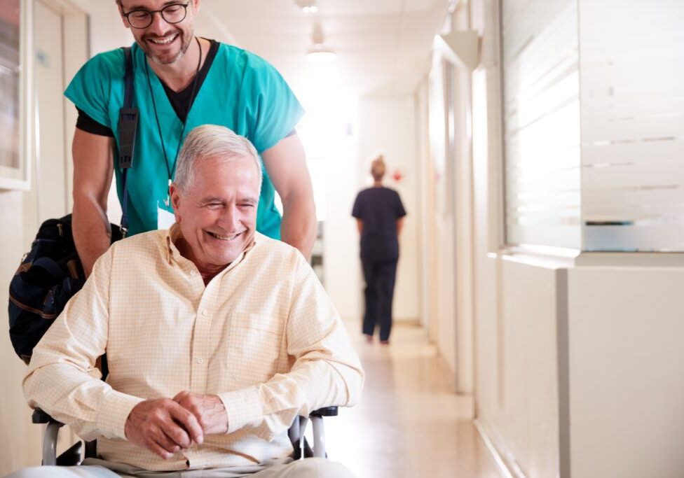Male,Orderly,Pushing,Senior,Male,Patient,Being,Discharged,From,Hospital