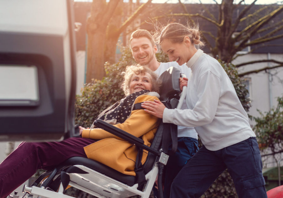 Two,Helpers,Picking,Up,Disabled,Senior,Woman,In,Wheelchair,For Two,Helpers,Picking,Up,Disabled,Senior,Woman,In,Wheelchair,For