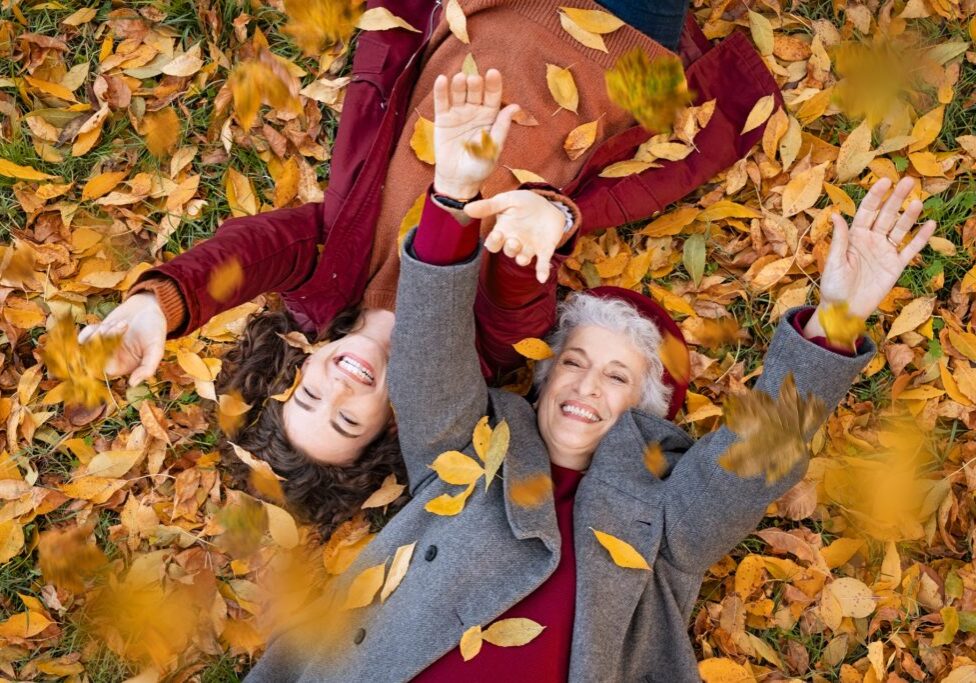 Senior,Grandmother,And,Smiling,Granddaughter,Lying,On,Yellow,And,Red