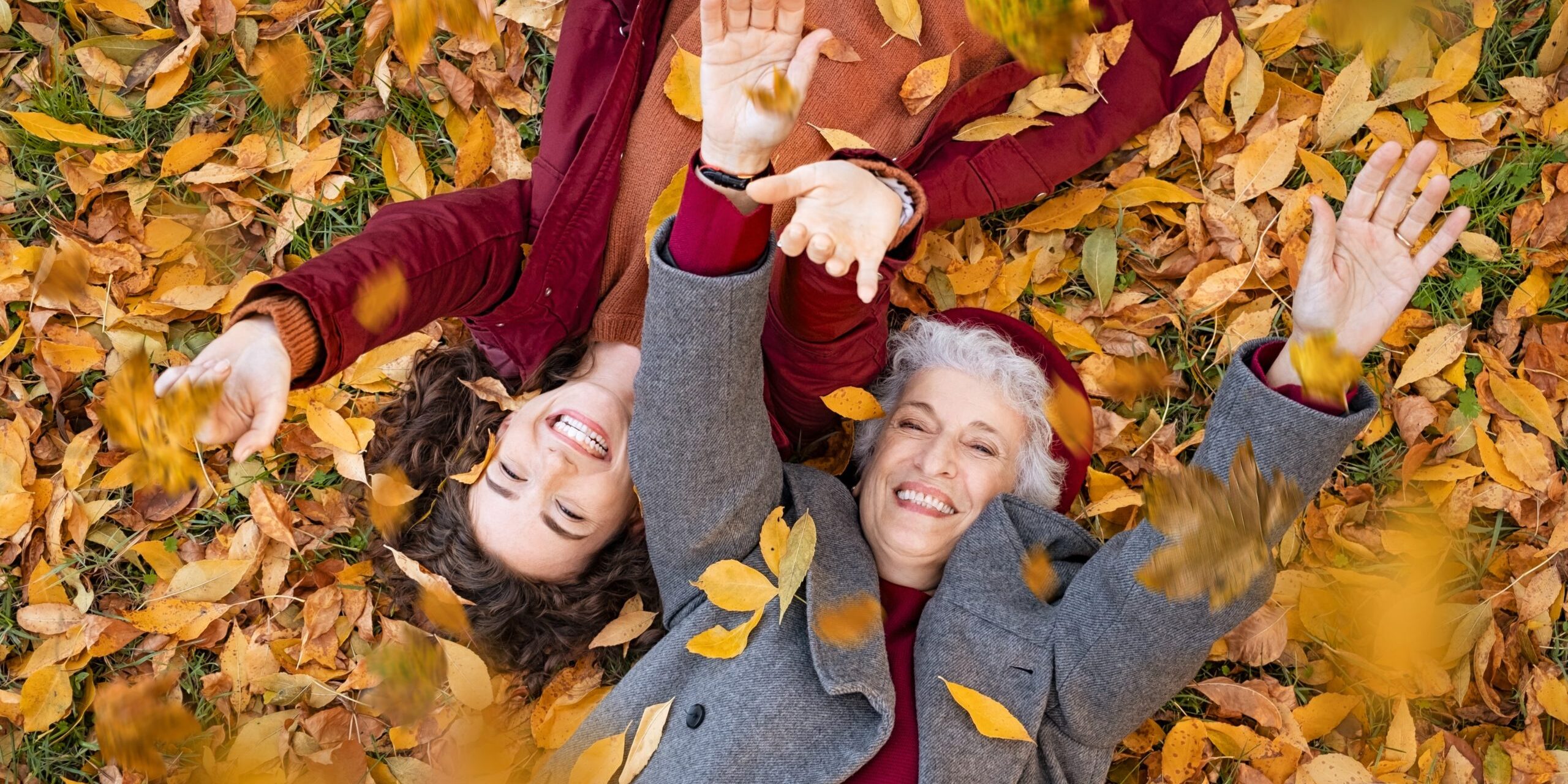 Senior,Grandmother,And,Smiling,Granddaughter,Lying,On,Yellow,And,Red