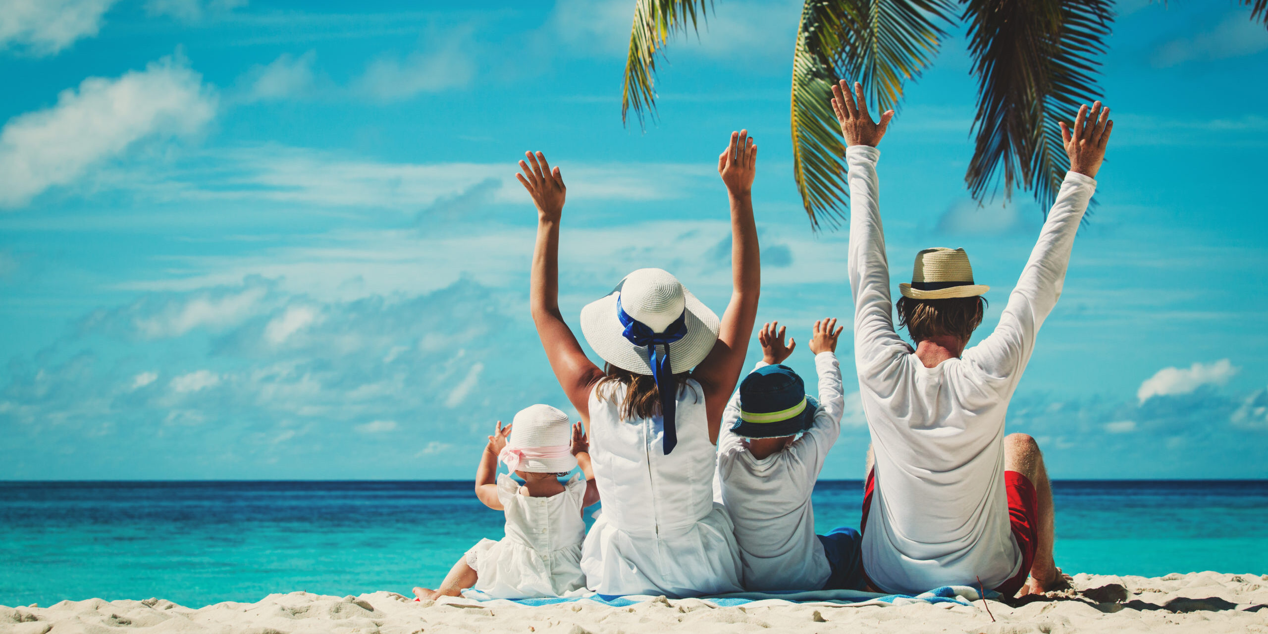 Happy,Family,With,Two,Kids,Hands,Up,On,The,Beach