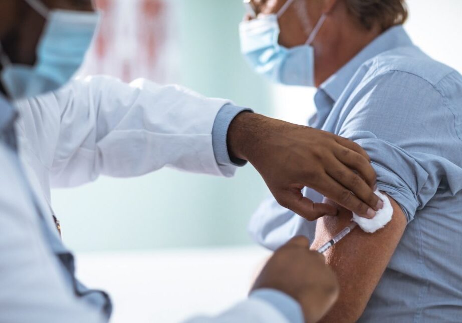 Close up of a mature man taking a vaccine in his doctors office